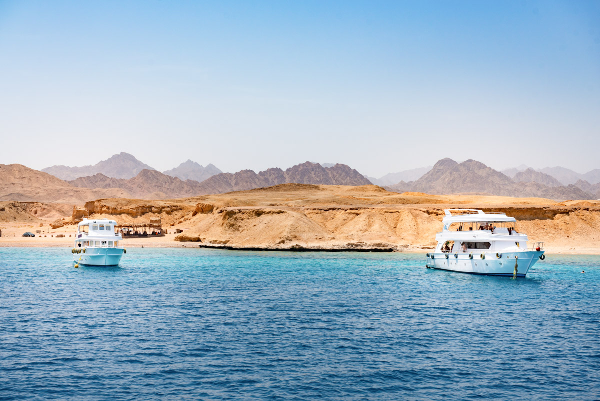Red Sea liveaboards moored in a bay surrounded by Egypt's desert landscape