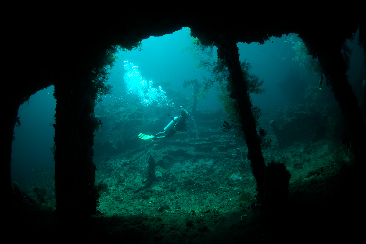 A diver swimming past the hold of the Liberty wreck in Tulamben, Bali.
