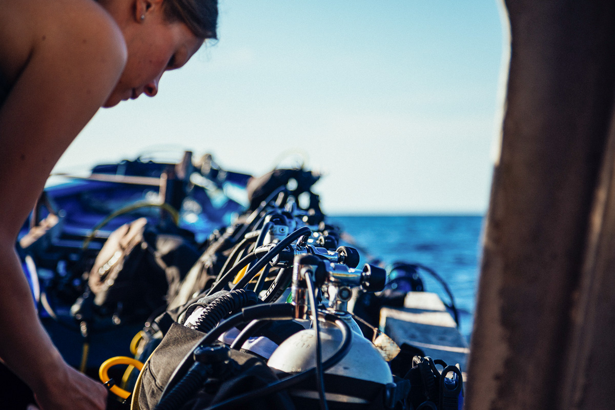 Dive instructor checking equipment onboard a dive liveaboard